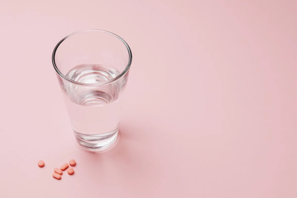 Persona revisando información de vitaminas junto a sus notas de salud